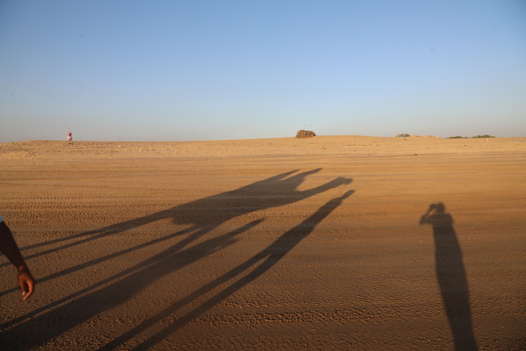 a shadow of two people standing in the desert