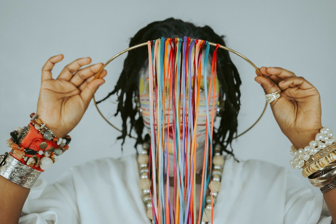 Person with colorful threads obscuring face